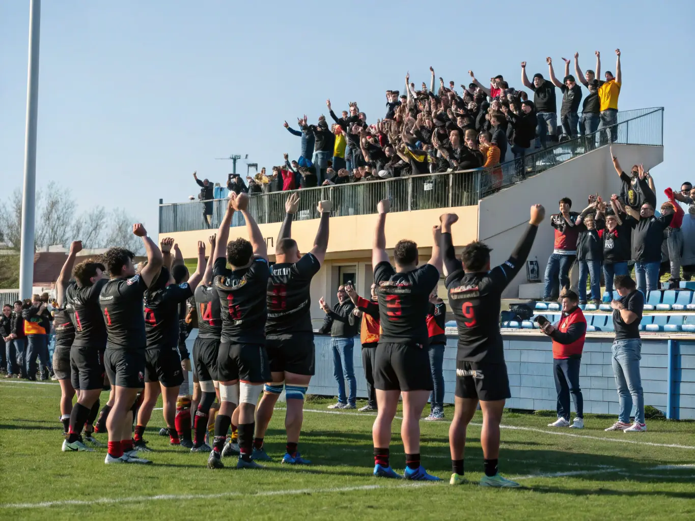 A dynamic shot of S.D.J. SYNDIKA DES JOUEURS members celebrating a successful event, capturing the joy and satisfaction of making a positive impact on the community and the Dampniat rugby club. The image should inspire others to join the cause.
